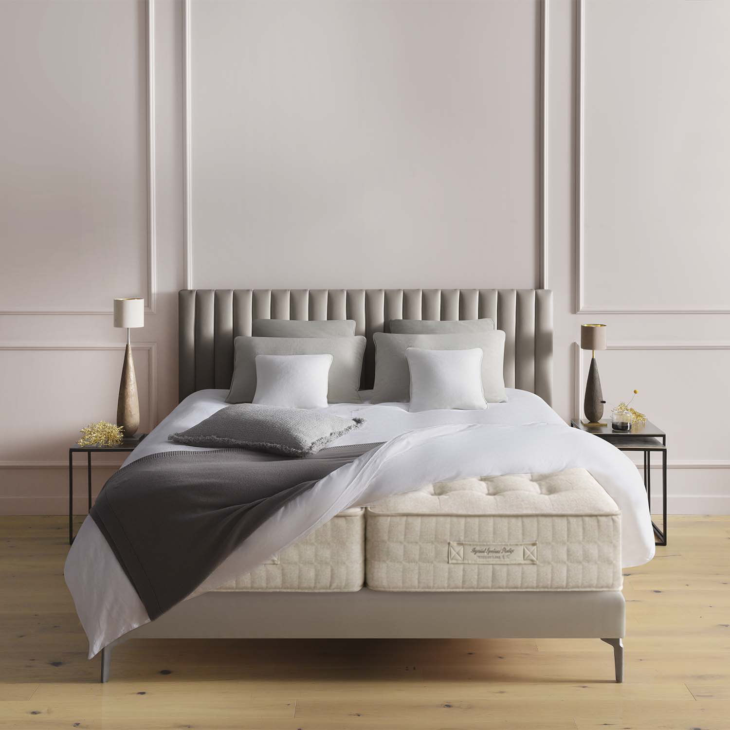 Bed with gray headboard and Treca Imperiale Symbiose Prestige mattresses in a bedroom setting
