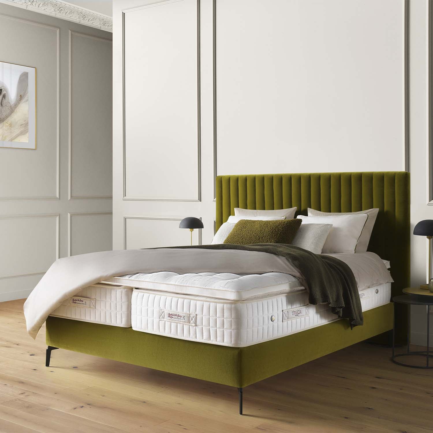 Green bed frame with white mattress with a Treca Opera topper and pillows in a bedroom setting
