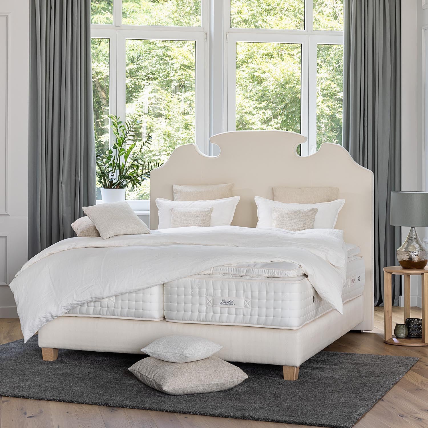 Treca Platinum Essentiel mattress on a white bed in a luxurious room with large windows
