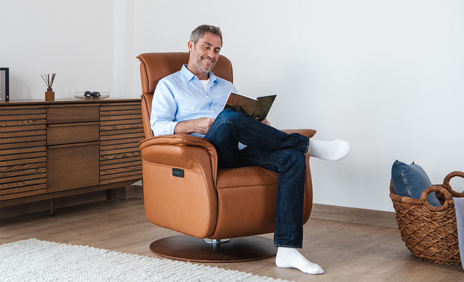 Man enjoying a book while sitting on an IMG Comfort Sedona Advanced Relaxer XL in a bedroom setting
