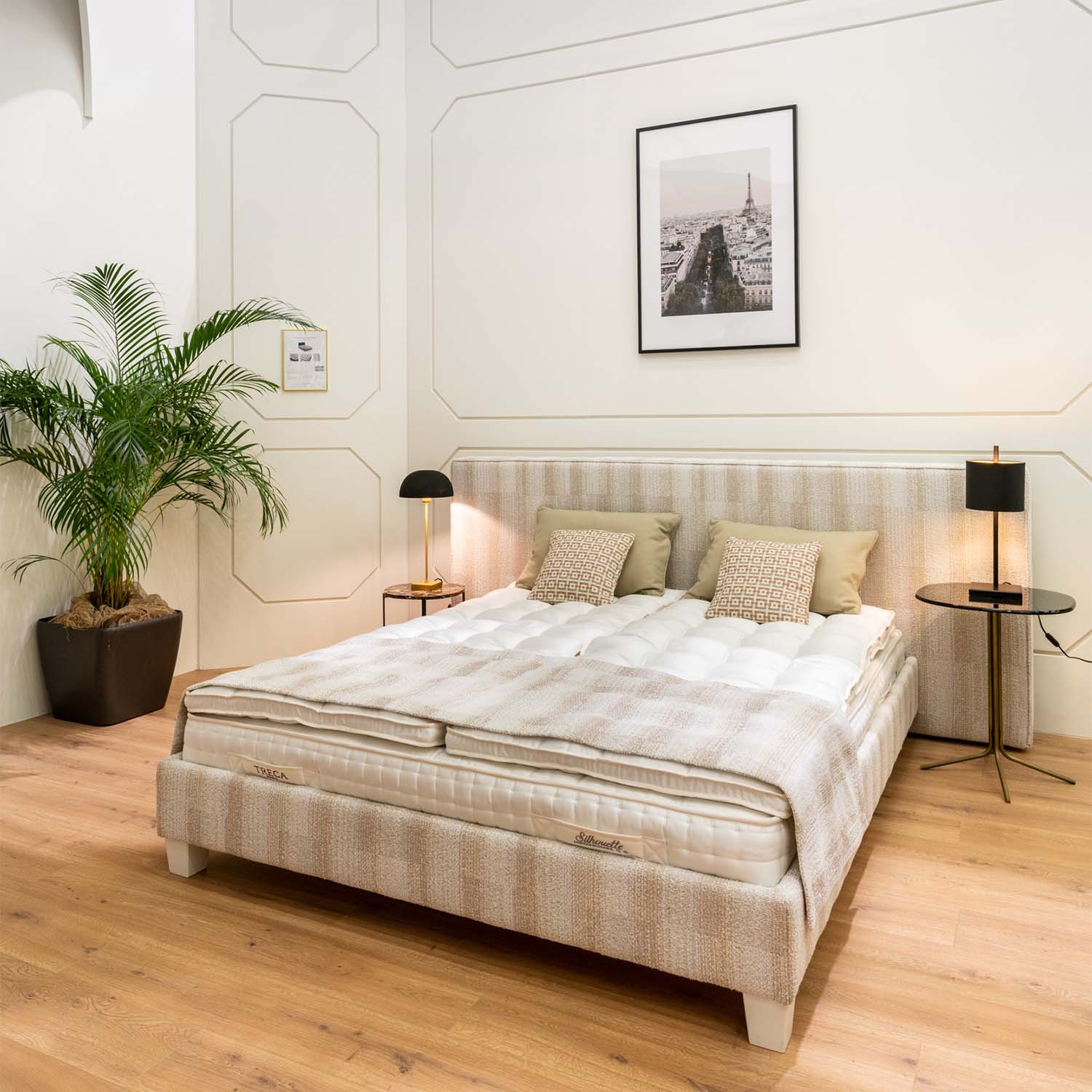 Bedroom with a large bed equipped with a Treca miniflex bed base, side tables, and decorative elements.
