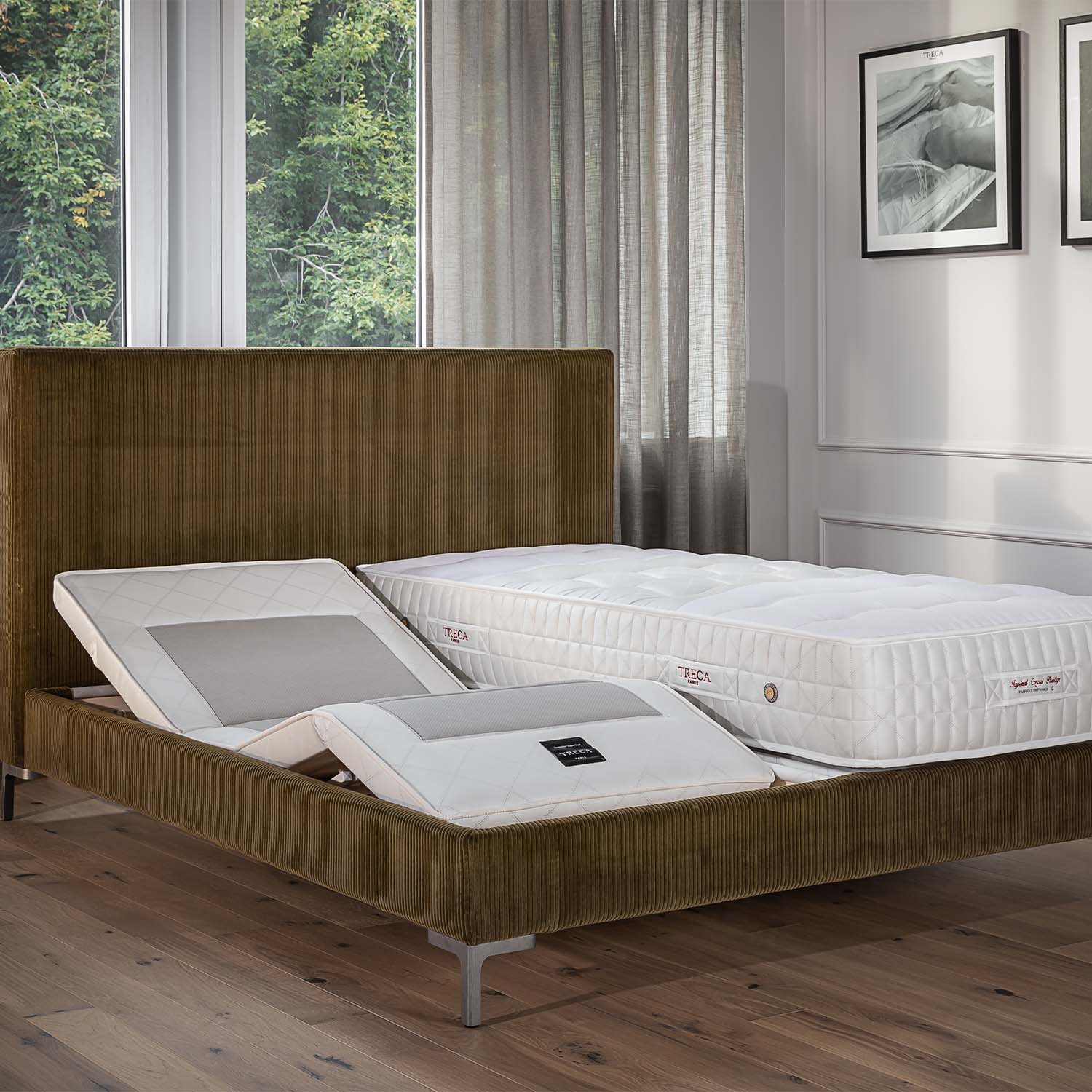 Bed with a brown headboard and Treca supercad bed base in a room with large windows and curtains.