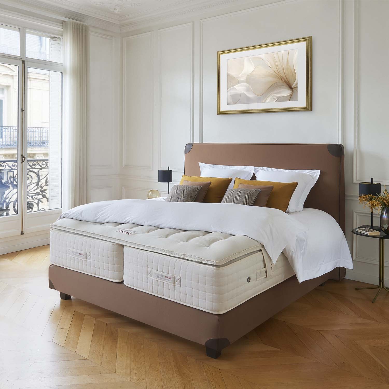Bedroom with a bed featuring a mattress with a Treca Paris topper on a wooden floor.